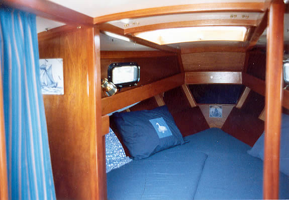 The cabin interior, showing the 6'8" double V-berth. The curtained 